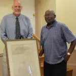 Dr. Darren Lisse (left) presents an 1841 edition of the Morning Star, an abolitionist newspaper, to James Taylor (right), president of the Jefferson County (W. Va.) Black History Preservation Society. 